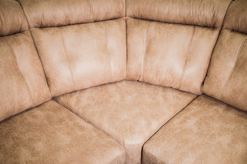 Close-up the Fragment of expensive beige leather sofa to indoors