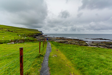 Rural path from Doolin to the Cliffs of Moher along the spectacular coastal route walk, geosites and geopark, Wild Atlantic Way, spring day in County Clare in Ireland