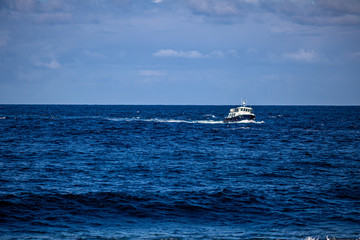Boat sailing in the calm blue waters of the Atlantic Ocean towards Inis Oirr Island, wonderful sunny day in the Aran Islands, Ireland