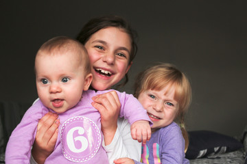Close up Portrait of Three Beautiful Sisters, One Cute Toddler Girl , 6 Month Old Baby Girl, 7...