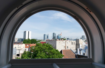 Fototapeta na wymiar view of modern high-rise hotels from the arched window in the old town of Tallinn..