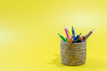 Colored pencils in a beautiful yellow background