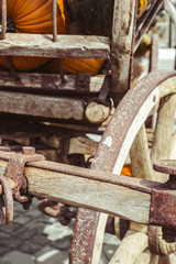Fototapeta na wymiar old carriage with rusty wheels and pumpkins