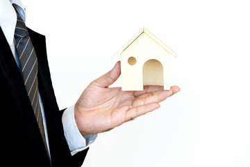 Fototapeta na wymiar Businessman hand holding a model home presenting on white background, Saving money for buy a new house or loan for plan business investment of real estate concept.