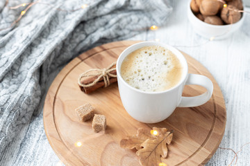 Coffee mug, sweater, cinnamon, decorated with led lights. Autumn mood. Cozy autumn composition. Hygge concept Soft focus
