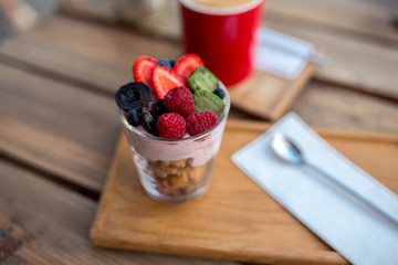 tasty dessert with different fruits on a wooden table in a cafe