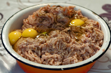Cooking - minced meat for homemade meatballs with broken raw eggs