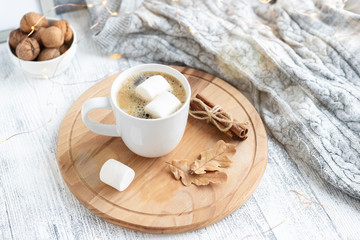 Obraz na płótnie Canvas Mug with coffee and marshmallow, sweater, cinnamon, decorated with led lights. Autumn mood. Cozy autumn composition. Hygge concept Soft focus - Image