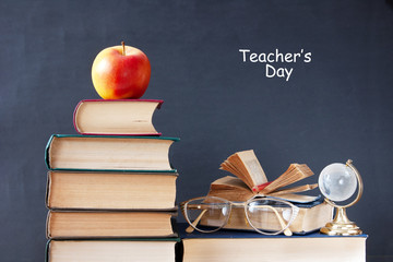 World Teacher's Day (still life with book pile, apple, globe and desk on artistic background)