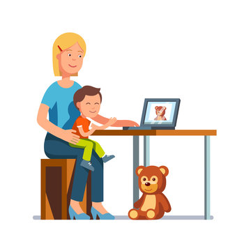 Mom sitting with a kid pointing at laptop with toy