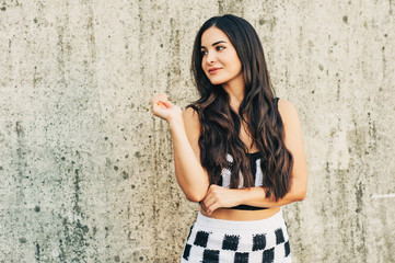 Outdoor portrait of attractive young woman with long black hair