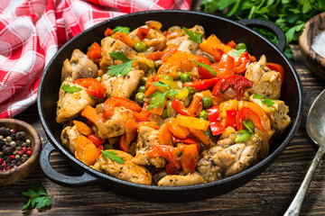 Chicken Stir fry with vegetables on wooden table.