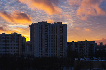 Dense urban development, buildings, city at sunrise and dawn. Sun flare. Smog and fog over the city.