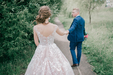 Beautiful wedding couple walking along road at nature