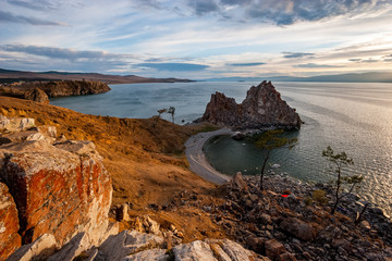 Beautiful view of the sacred rock of Shamanka on the island of Olkhon at sunset. There are light...