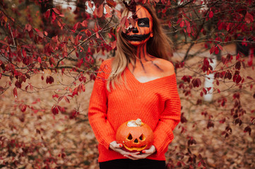 Young blonde girl with halloween face art posing outdoor.  Helloween celebration concept.