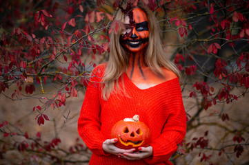 Young blonde girl with halloween face art posing outdoor.  Helloween celebration concept.
