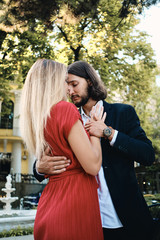 Young beautiful romantic couple sensually dancing on date in garden of restaurant