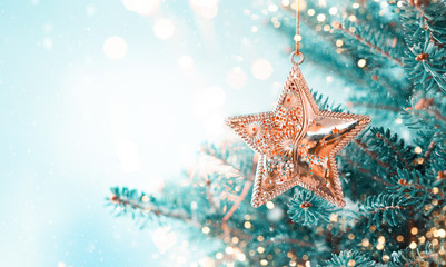 Christmas fir tree branches with golden star decoration  on blurred blue background. Christmas and Winter concept. - Powered by Adobe