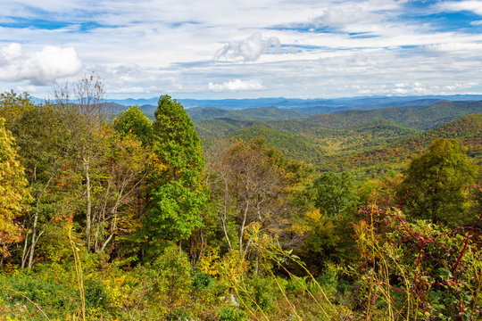 River Overlook; on the Blue Ridge Pkwy.  Blue Ridge Mountains with white clouds almost covering the blue sky as summer is ending and autumn is just beginning. The layer after layer of mountaintops alm