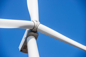 Wind turbines generating electricity with blue sky. Close up of Wind turbine producing alternative energy © spyrakot