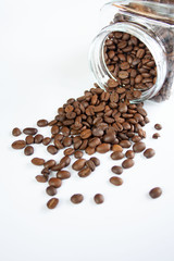 Coffee beans spilling out of the jar, white background