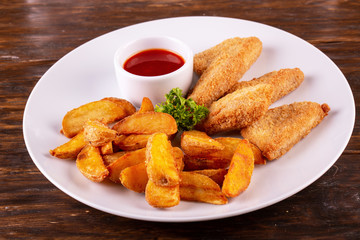 Fish nuggets breaded with potato and ketchup