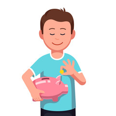 Boy holding piggy bank putting coin money into it