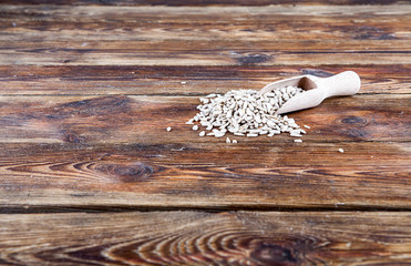 Spatula, scoop with shelled sunflower on wooden background (view from a different perspective in the portfolio)
