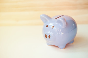 Close up of piggy bank standing on wooden background with copy space. Tonet.