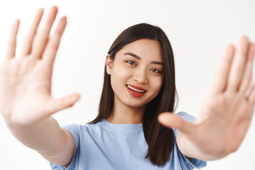 What beautiful scenery girl found perfect angle take shot. Attractive creative asian female stretch hands towards camera framing search inspiration smiling delighted contemplating moment happy