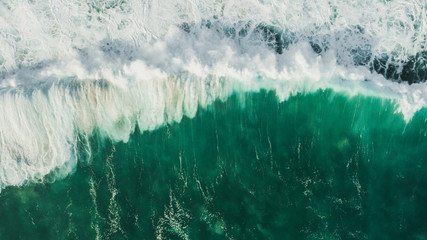 Aerial wave background. Drone shot directly from above, green turquoise color, huge waves. Empty space