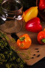 Preservation of vegetables. On the table are peppers and dill. Near an empty can. View from above. Macro.