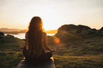 Gordijnen Vrouw die yoga alleen mediteert bij zonsopgangbergen. Van achteren bekijken. Reizen Lifestyle spirituele ontspanning concept. Harmonie met de natuur. © Oleg Breslavtsev