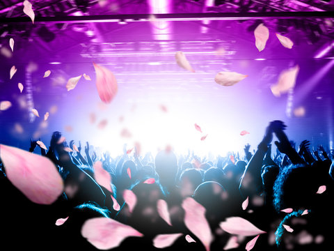 Concert Crowd Under A Rain Of Confetti From Above, Background Is A Lit Stage