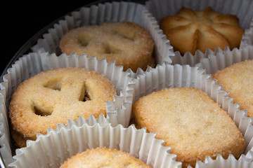 Box of sugar cookies in paper baskets in the dark