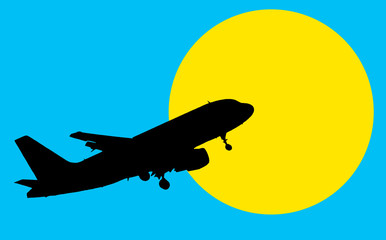 Silhouette of the plane in the blue sky against the background of the yellow sun.