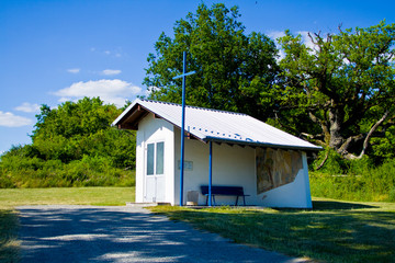 Small white chapel on a meadow in front of a forest in Bavaria, Germany