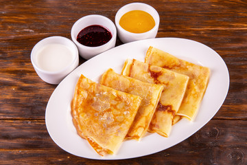 Pancakes with oil and sour cream, jam and honey