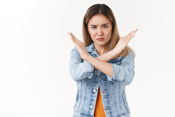 No stop it. Displeased serious-looking assertive intense disagree asian blond girl making cross...