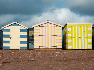 Three colourful beach huts in Teinmouth Devon