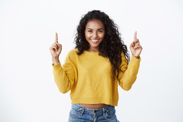 Your advertisement up here. Cheerful attractive encouraged young african-american woman with curly...