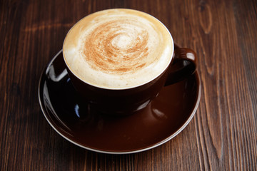Cappuccino on a brown wooden background. Menu
