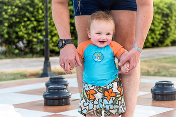 little boy / girl standing in front of father, holding hands