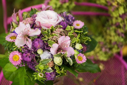 Flower bouquet with flower wreath on a garden table