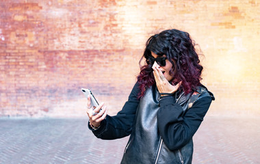 Fototapeta premium young girl looking at her cell phone in amazement
