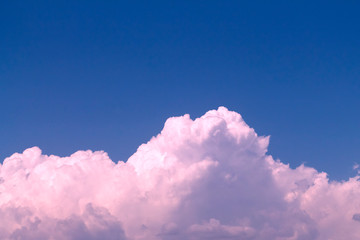 Pink fluffy clouds in blue sky 