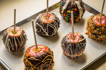 gourmet caramel apples covered in chocolate and assorted nuts and candy pieces