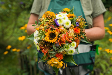 Florist holds flower bouquet in hand