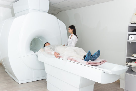 Radiologic technician and man patient lying on a CT Scan bed. preparing for MRI magnetic resonance imaging in a hospital - Powered by Adobe